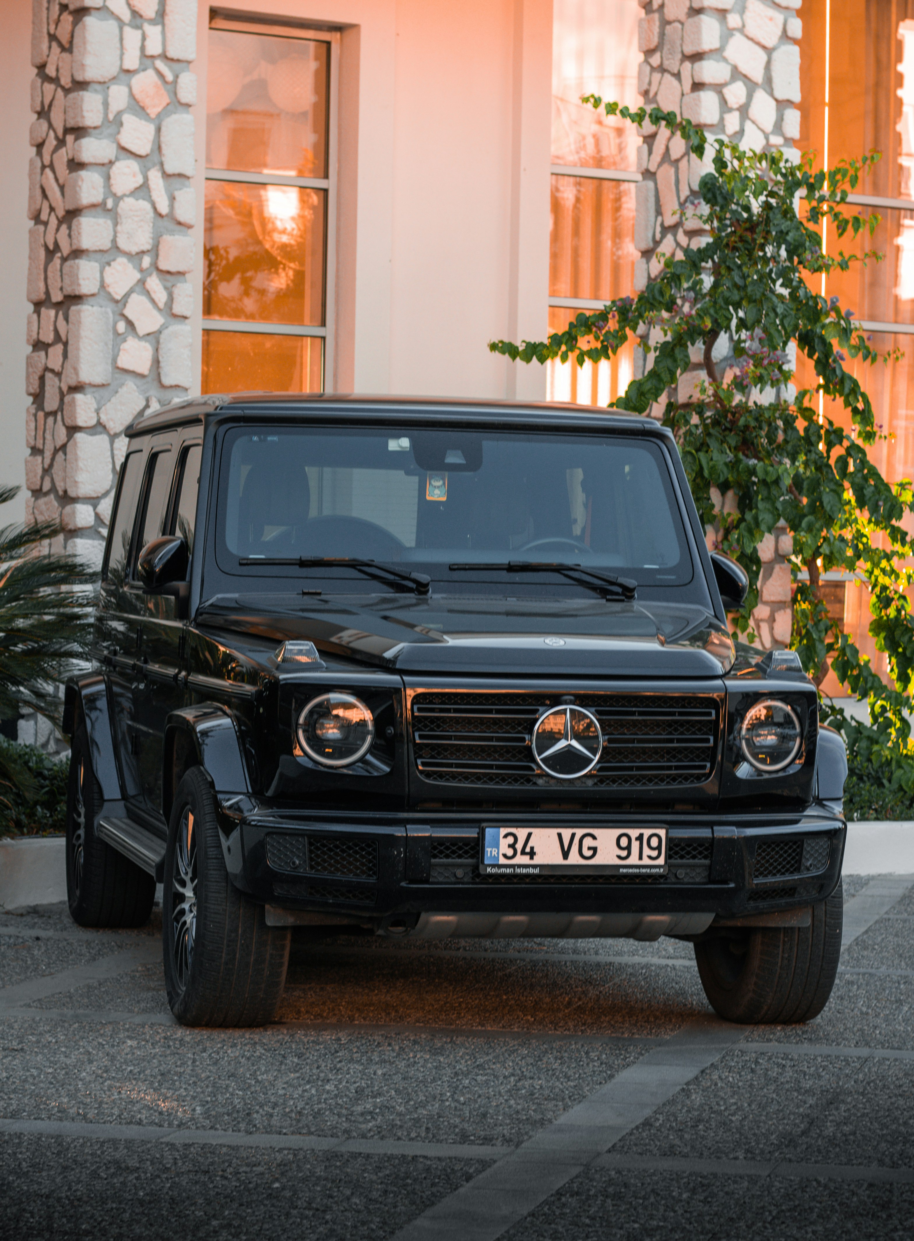 black mercedes benz car parked beside brown brick wall